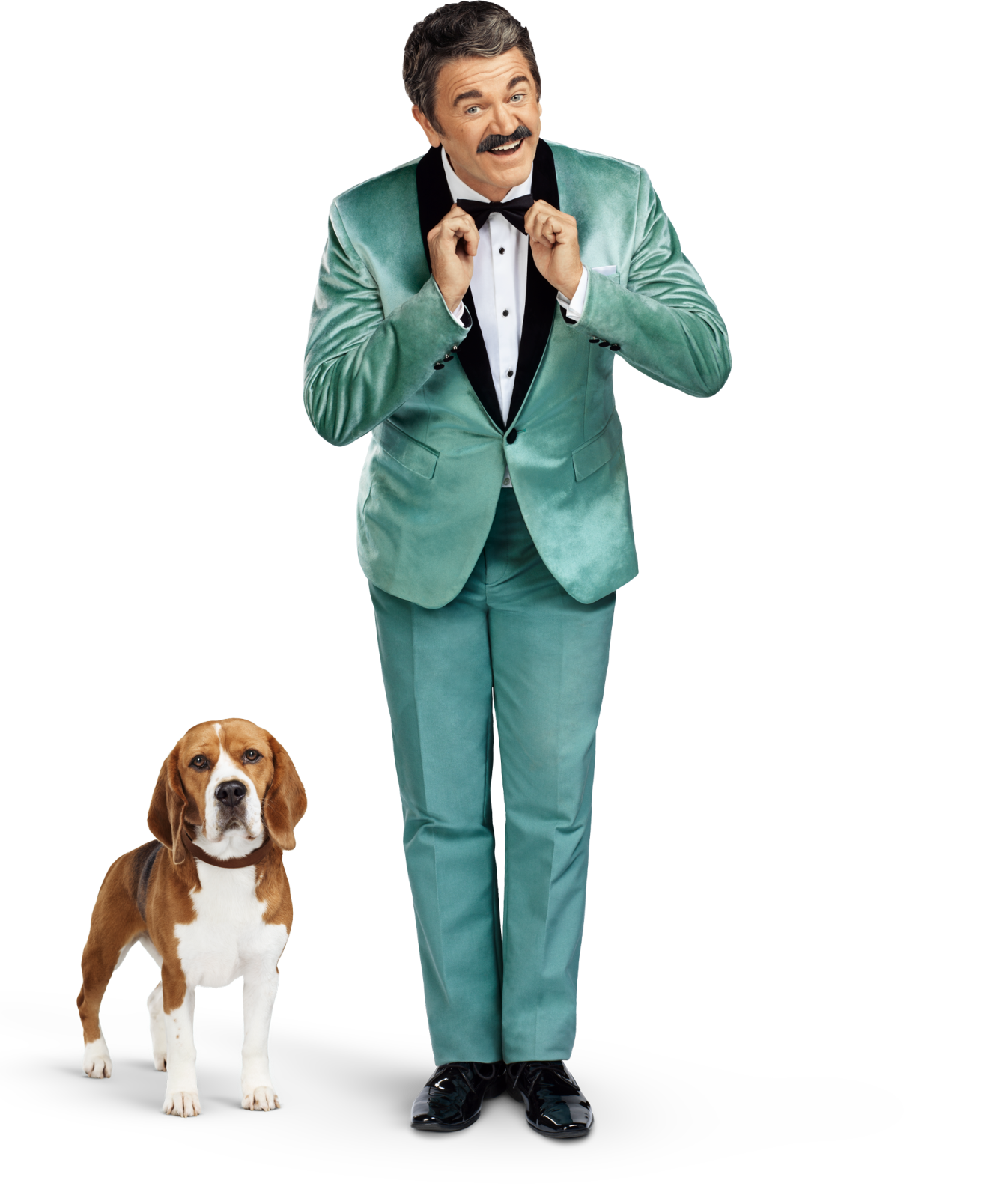 Man with mustache and tuxedo smiling with beagle standing to his left
